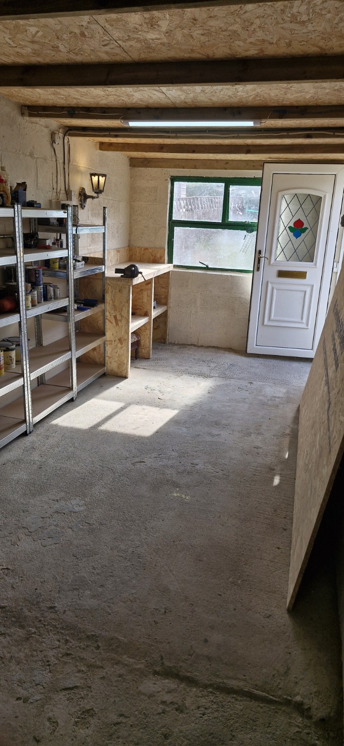 Original photograph of the garage workshop with shelves, workbench and side door
